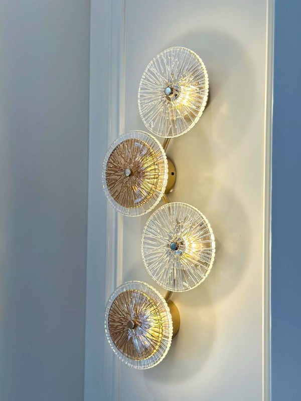 Elegant four glass disc wall sconce featuring hand-crafted glass discs and a brass finish.
