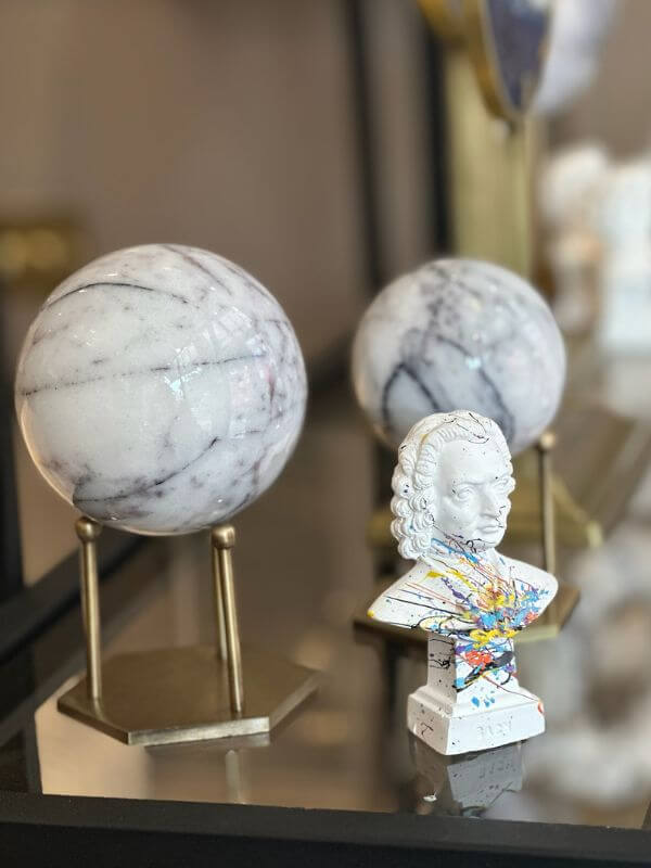 White marble decorative sphere with lilac veins on a hexagonal stand, featuring an antique brass finish.