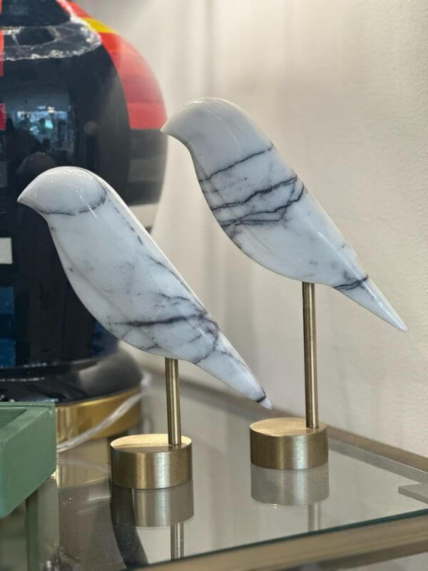 White marble bird decorative object with grey veins on brass stand, adding elegance to home decor.