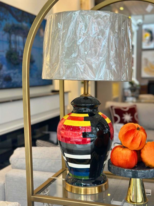 Multicolor ceramic table lamp with bold oval base and vibrant red, yellow, blue, and black design, perfect for modern interiors.