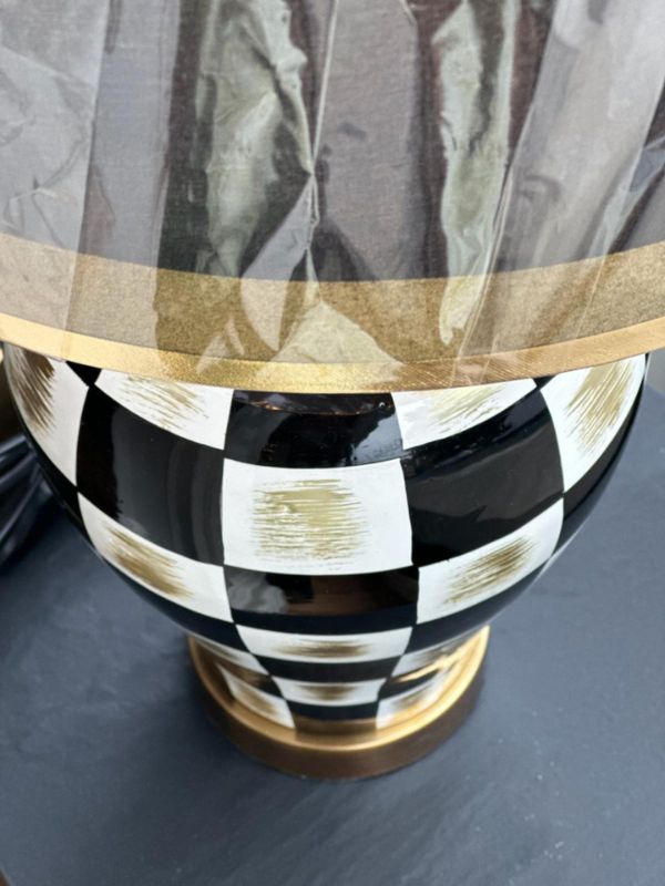 Black and gold checkered ceramic table lamp with glossy finish and matching lampshade, showcasing modern glam style.