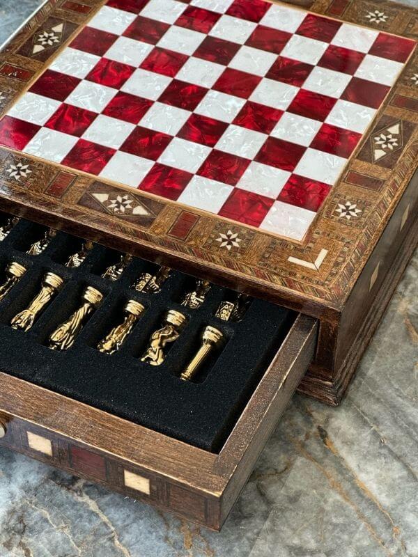 Handcrafted small chess set showing ornate checkered board and detailed chess pieces in a neatly organized drawer.