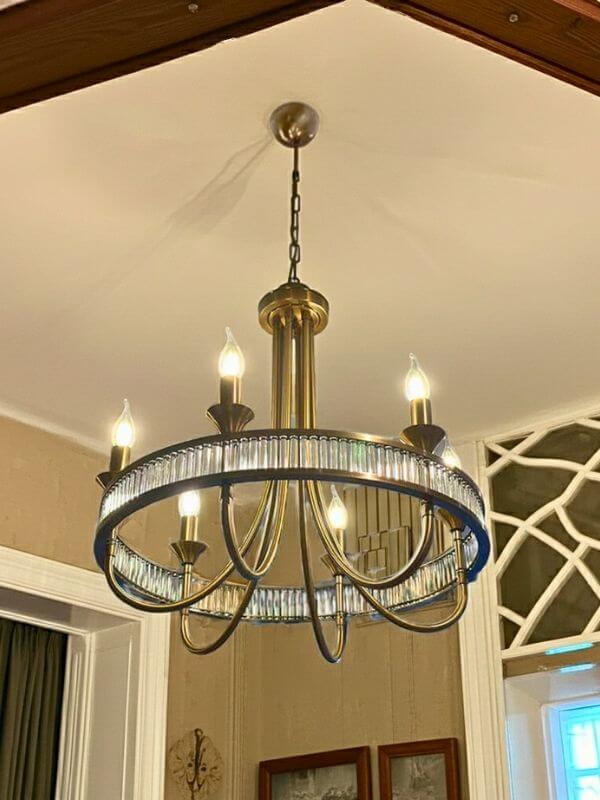 Modern round crystal chandelier elegantly illuminated in a stylish interior setting.