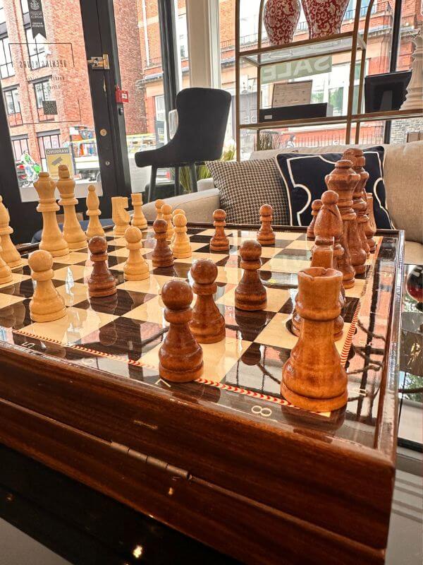 Large classic chess set displayed elegantly on a polished surface in a stylish living space.