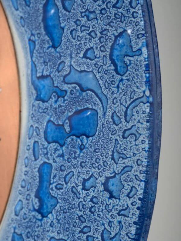 Close-up of a decorative copper glass sacred geometry decor piece with intricate blue textures and patterns.