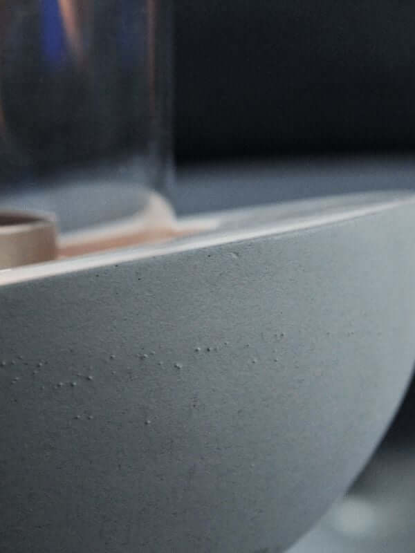 Close-up of the decorative glass concrete fireplace showcasing the textured concrete base and elegant design.