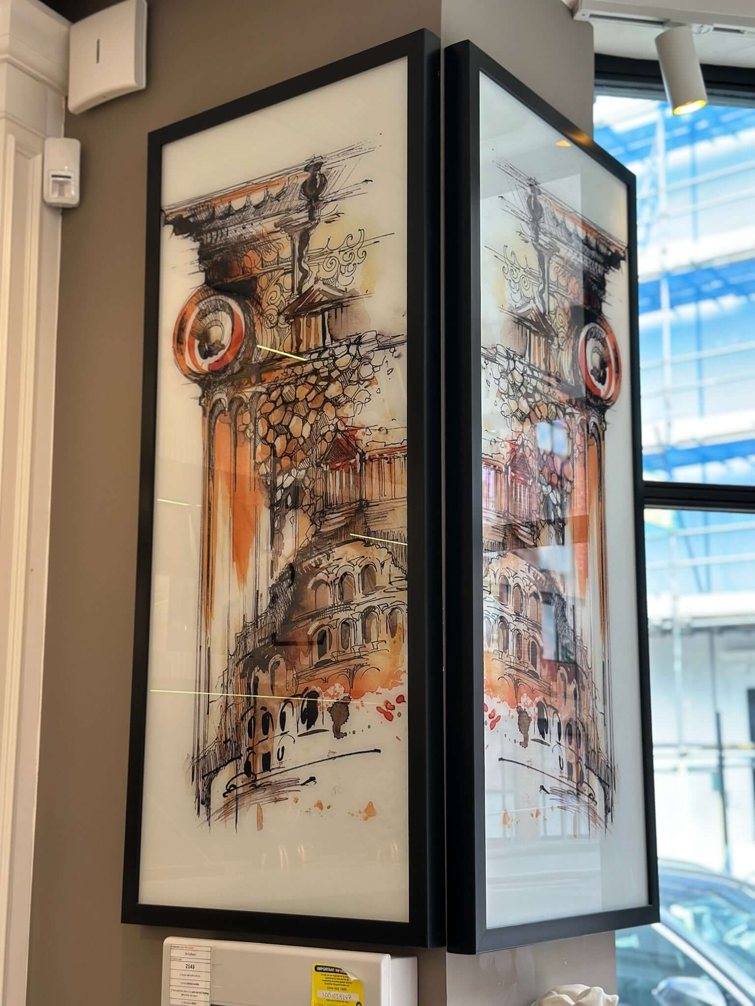 Framed glass wall art black metal frame showcasing a vibrant illustration of classical architecture with elegant detailing.
